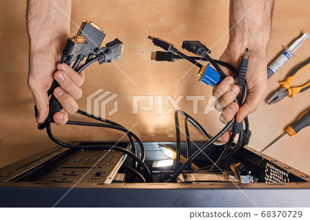 man holding cables and selecting the necessary one 68370729