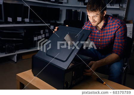 Technician looking at the broken system unit Technician looking at the broken system unit 68370789