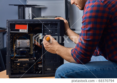 man with screwdriver dissembling a system man with screwdriver dissembling a system 68370794