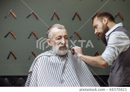 Senior man visiting hairstylist in barber shop. Senior man visiting hairstylist in barber shop. 68370821