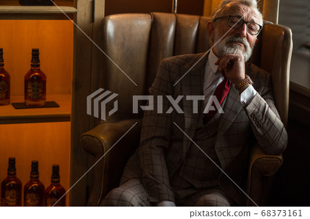 Toned retro styled portrait of businessman sitting in armchair at office Toned retro styled portrait of businessman sitting in armchair at office 68373161