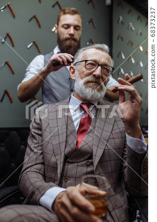 Senior man visiting hairstylist in barber shop. Senior man visiting hairstylist in barber shop. 68373237