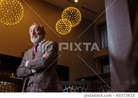 Styled portrait of businessman sitting in armchair at office Styled portrait of businessman sitting in armchair at office 68373618