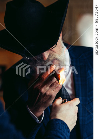 Stylish old man in wide brimmed hat and rich blue mens suit smok Stylish old man in wide brimmed hat and rich blue mens suit smok 68373647