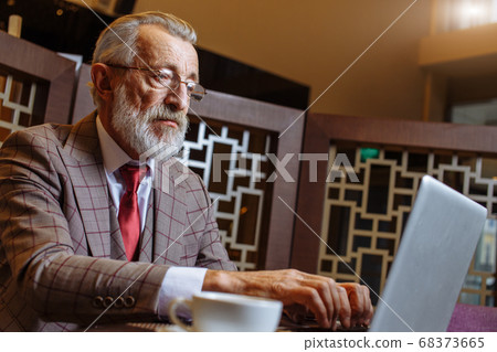 Old Businessman with laptop at coffee break in his office concept 68373665