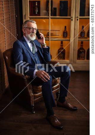 Experienced old private physician talking on smartphone with pat Experienced old private physician talking on smartphone with pat 68373743