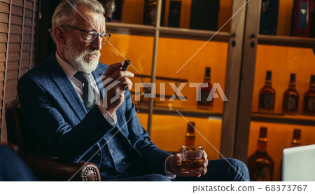 Senior dramatist looking at laptop, creating novel while sitting in pub. Senior dramatist looking at laptop, creating novel while sitting in pub. 68373767