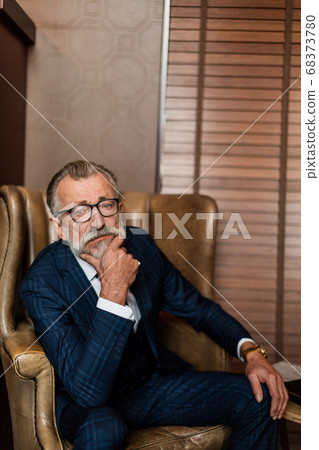 Elderly businessman in formal suit with whiskey and cigar at lux Elderly businessman in formal suit with whiskey and cigar at lux 68373780