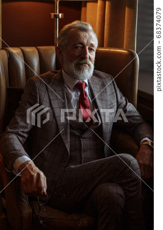 Toned retro styled portrait of businessman sitting in armchair at office 68374079