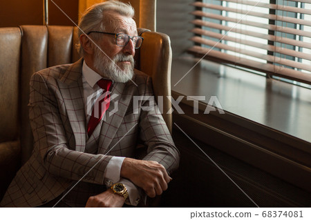 Toned retro styled portrait of businessman sitting in armchair at office 68374081