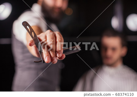 Close up of Barber holding professional equipment tools of Hairdresser -scissors 68374110