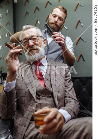 Senior man visiting hairstylist in barber shop. Senior man visiting hairstylist in barber shop. 68374155