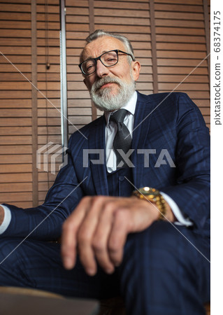 Elderly businessman in formal suit with whiskey and cigar at luxury interior Elderly businessman in formal suit with whiskey and cigar at luxury interior 68374175