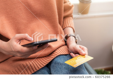 Woman holding smartphone and credit card with paying for shopping online. 68375266