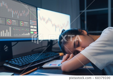 Woman trader tired and sleeping on computer with graphs analysis candle line on table in night 68379100