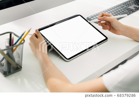 Woman holding digital tablet mockup of blank screen and computer on the table office.  68379286