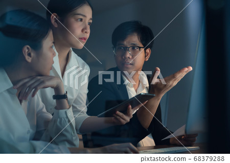 Asian business people working hard late together and planning with computer in office at night. 68379288