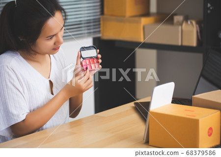 Asian female seller using a tablet selling Asian female seller using a tablet selling 68379586