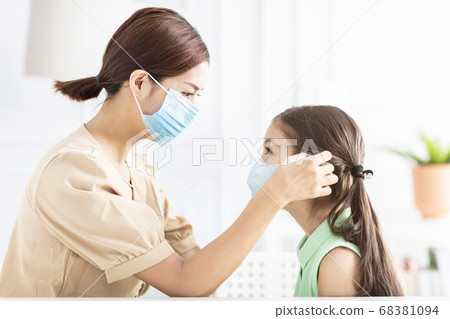 mother help her daughter wearing healthy face mask mother help her daughter wearing healthy face mask 68381094
