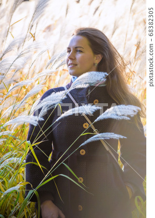 girl walks on nature among the reeds and shows her 68382305