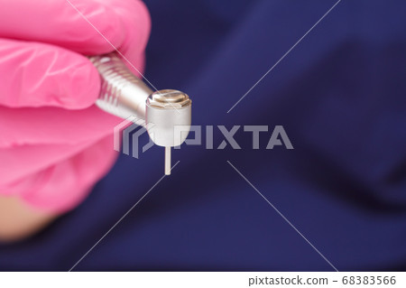 Dentist's hand in glove with dental handpiece on 68383566