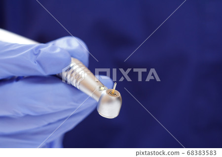 Dentist's hand in glove with dental handpiece. Dentist's hand in glove with dental handpiece. 68383583