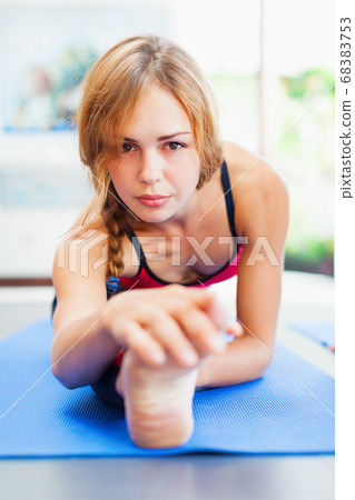 Young active woman doing front split stretching Young active woman doing front split stretching 68383753