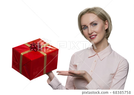 Cheerful positive blond woman holding big present box in her hand. 68385758