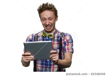 Stressed crying teenage boy is looking at tablet pc screen. 68386046