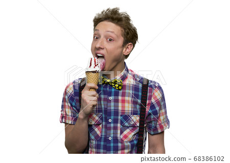 Sloppy teenage boy is licking ice-cream with his mouth opened. 68386102