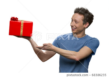 Teen boy's presenting red gift box. 68386235