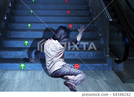 Scary zombie with blood and wound on his body crawling on the stairs Scary zombie with blood and wound on his body crawling on the stairs 68386282