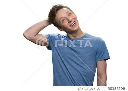 Skinny teen guy is daydreaming touching his head. 68386306
