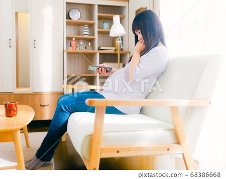 Pregnant woman operating a smartphone 68386668
