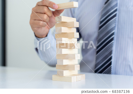 Business people play wooden games together, divide the average investment value of a business and jointly manage risks, Alternative risk plan and strategy in business. 68387136