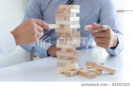 Business people play wooden games together, divide the average investment value of a business and jointly manage risks, Alternative risk plan and strategy in business. Business people play wooden games together, divide the average investment value of a business and jointly manage risks, Alternative risk plan and strategy in business. 68387203