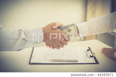 Businessmen make dollar payments while signing an investment agreement to be a partner in an illegal and successful manner, Bribery and corruption concept. Businessmen make dollar payments while signing an investment agreement to be a partner in an illegal and successful manner, Bribery and corruption concept. 68387671