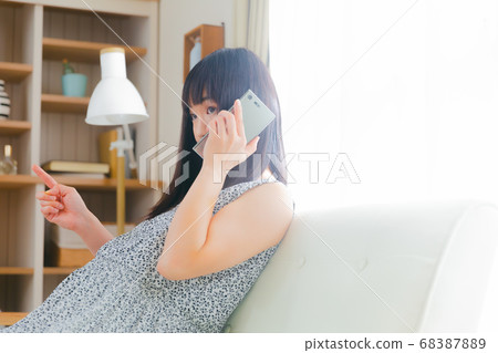 Pregnant woman holding a smartphone conversation 68387889