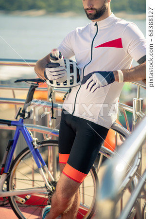 Athletic cyclist with sports water bottle and helmet 68388127