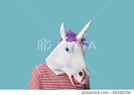 man wearing a unicorn mask on a blue background 68388706