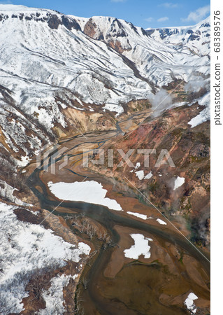 View of the Valley of Geysers, and Kronotsky nature reserve from a helicopter after a spring snowfall on the Kamchatka Peninsula View of the Valley of Geysers, and Kronotsky nature reserve from a helicopter after a spring snowfall on the Kamchatka Peninsula 68389576