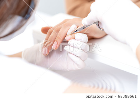 Close up of manicurist using manicure scissors 68389661