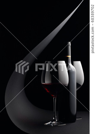Bottle and glasses of red wine on a black 68389702
