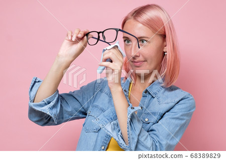 Caucasian woman cleaning glasses or lens with microfiber tissue Caucasian woman cleaning glasses or lens with microfiber tissue 68389829