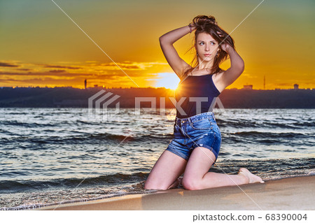 A young brunette girl in a black T-shirt and denim A young brunette girl in a black T-shirt and denim 68390004