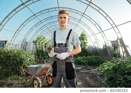 Man with garden tools.Young happy farmer posing 68390383