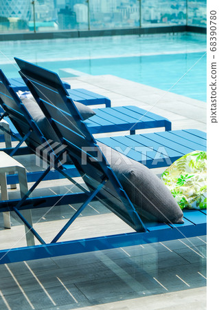 Swimming pool with chaise loungers background Swimming pool with chaise loungers background 68390780