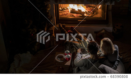 Young couple admires the fire in the fireplace, top view Young couple admires the fire in the fireplace, top view 68390808