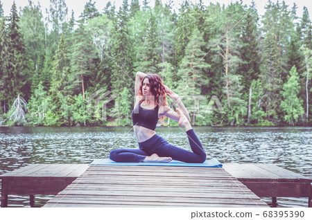 Beautiful girl in a yoga pose on the lake. Eka Beautiful girl in a yoga pose on the lake. Eka 68395390