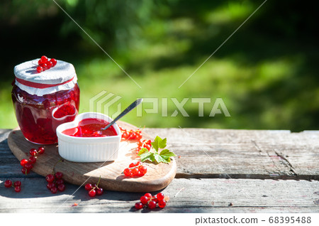 Red, juicy berries of red currants and jars of Red, juicy berries of red currants and jars of 68395488